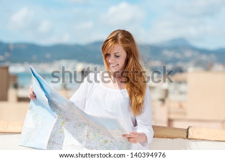 Woman with a route map planning her sightseeing while on vacation at the coast