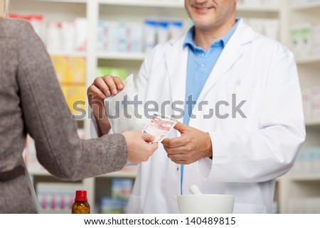 client paying 10 euro at the counter in pharmacy