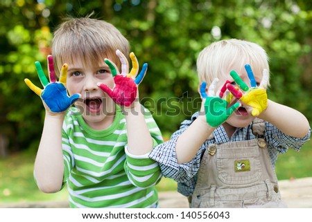 Two children showing their colorful painted hands