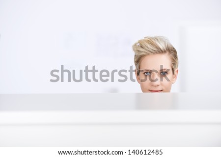 Portrait of young businesswoman smiling in office cubicle