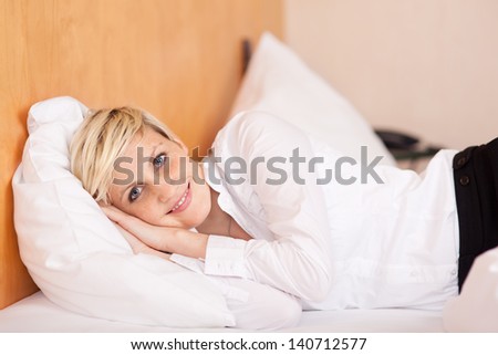 Portrait of relaxed young businesswoman lying on bed at home