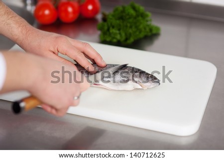 cook preparing fish in a commercial kitchen