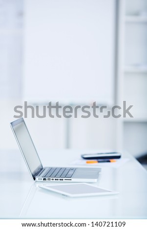 Silver laptop and tablet on white table