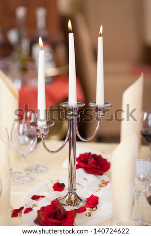 Closeup of lit candles on holder at restaurant table