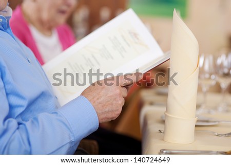 elderly couple watchin the menu in restaurant