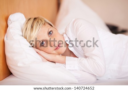 Relaxed young businesswoman sleeping on bed in hotel room