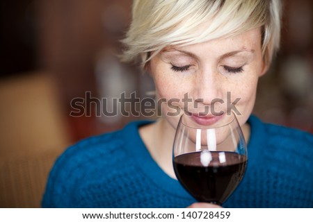 Closeup portrait of young female customer drinking red wine with eyes closed