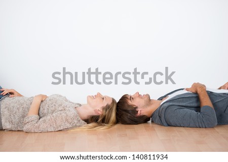 Couple Lying Head To Head In An Empty Room