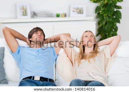 couple sitting on sofa thinking of something serious couple sitting on sofa thinking of something serious