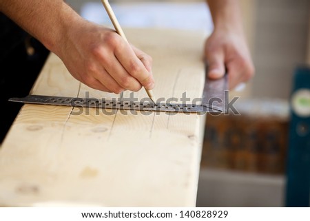 Carpenter making marks on a wooden beam