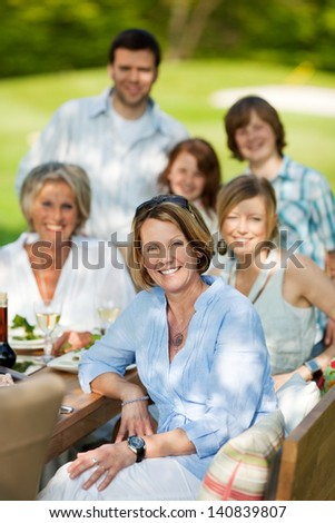 happy family sitting at table and having a garden party
