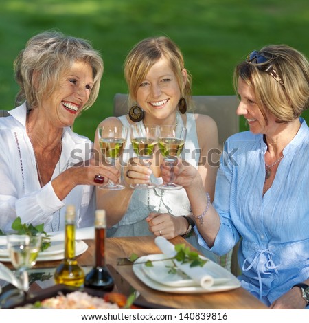 Happy Women Saying Cheers With White Wine At The Garden Party