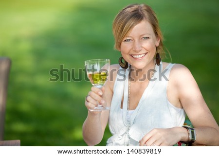 happy women saying cheers with white wine at the garden party