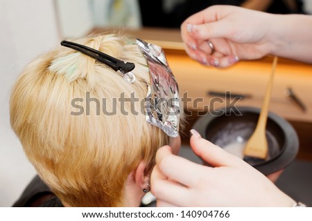 blonde female having some new highlights at hair salon