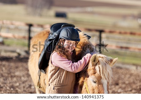 Young horse-rider girl wearing a modern horse riding helmet