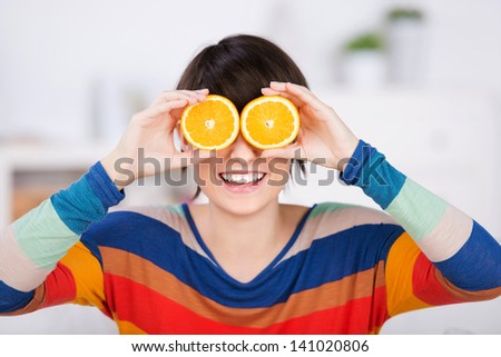 Smiling woman holding a slice of orange fruits