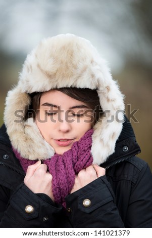Young woman, warmly dressed, but freezing in winter