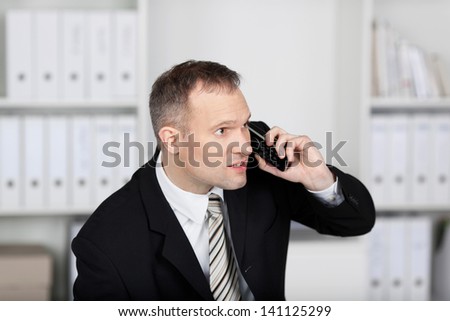 Businessman sitting and talking on the telephone at the office