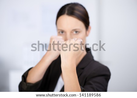 Portrait of angry businesswoman with clenched fists in office