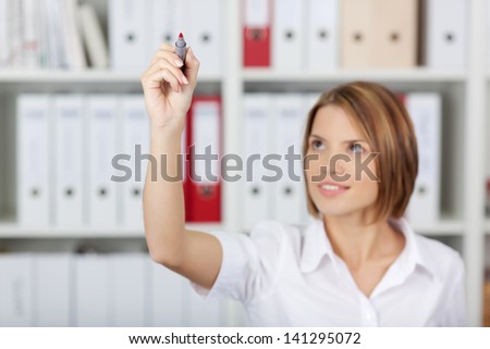 Beautiful secretary write something in the air against the files background