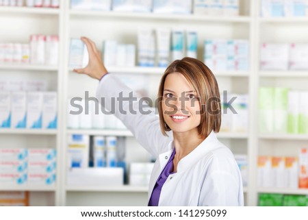 Portrait of a young woman pharmacist selecting a medication