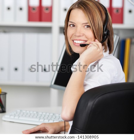 Rear view of female call center employee working on desktop computer