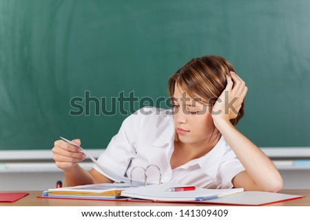 Portrait of teacher thinking and looking on her lesson plan