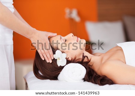 Relaxing fresh woman having head massage in spa