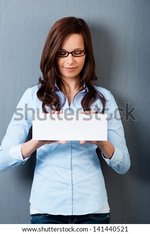 Looking down woman with glasses showing a white card