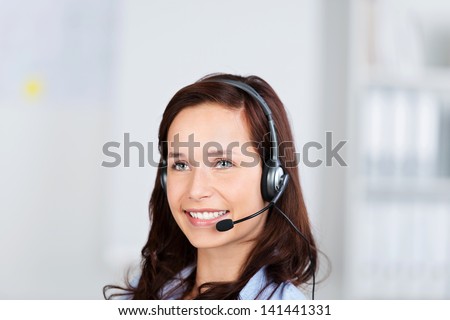 Attractive businesswoman wearing a headset listening to the conversation, conceptual of customer support, a receptionist or a call centre operator