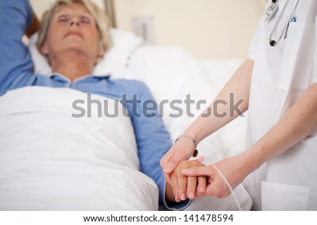 Cropped image of female doctor checking patients pulse in hospital