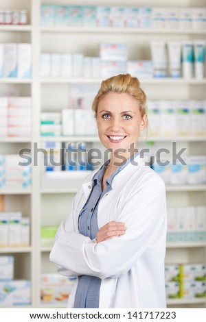 Portrait of a confident female pharmacist smiling in front of medicines at drugstore