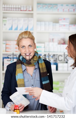 Portrait of a female customer buying medicine at the pharmacy