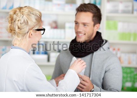 Young happy male customer buying medicine at the pharmacy