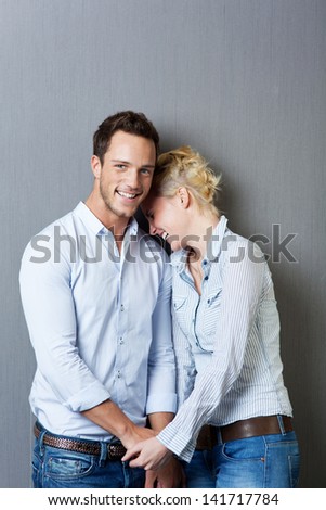 Laughing young couple standing against blue background