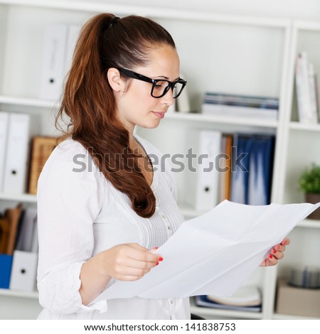 Portrait of businesswoman reading the white paper inside the office