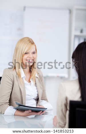 young woman holding an application folder in an interview in the office