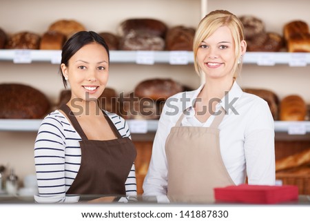 Portrait of confident waitresses standing together at cafe counter