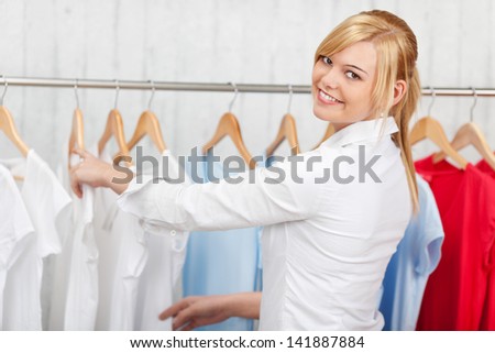 Confident Young Woman Choosing Shirt In A Shop