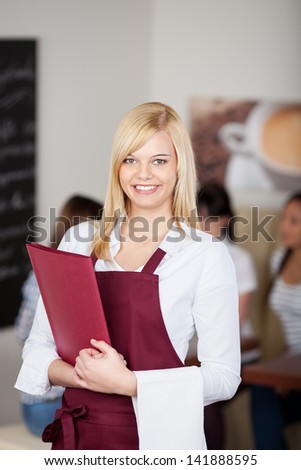 Portrait of confident cafe waitresses holding menu in cafe