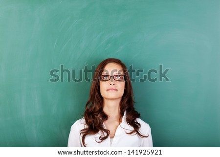 Looking up female with glasses over the green board background