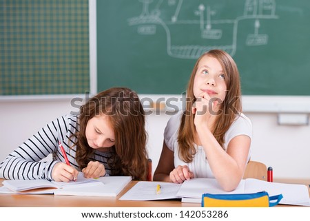 Two students in classroom studying their lesson in school