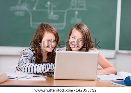 Portrait of schoolgirls studying in front of laptop at the classroom