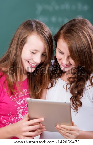 Two cheerful female studying with digital laptop in a close up shot