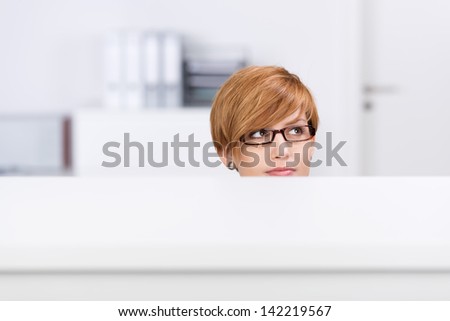 Young businesswoman with red hair thinking in white office