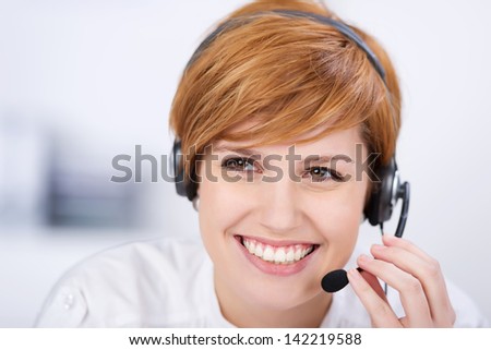 closeup of happy female customer service executive speaking on headset in office