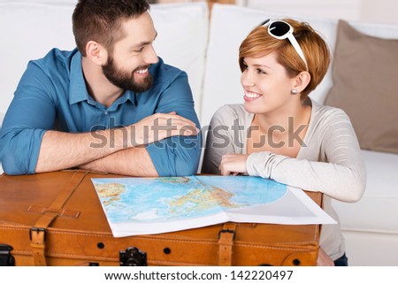 Young Happy Couple Planning A Travel With Map