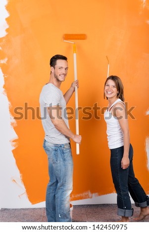 Happy couple painting the interior of their new house