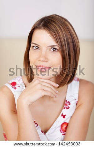 Portrait of a beautiful blond woman with short hair posing for camera resting her chin on the hand