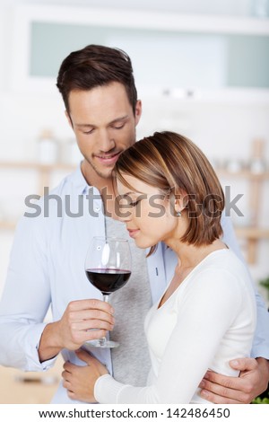 Portrait of husband and wife smelling a red wine in a close up shot